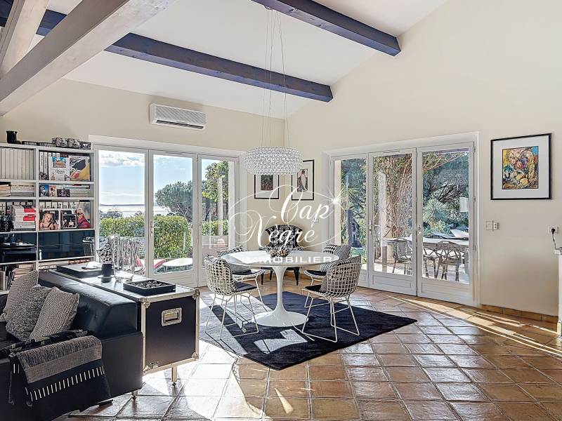 Séjour spacieux avec salon, salle à manger et cuisine ouverte offrant vue sur la mer et accès piscine